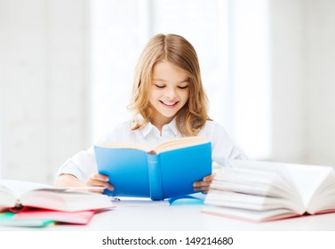 education and school concept - little student girl studying and reading book at school - Powered by Shutterstock