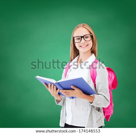 education and school concept - little student girl reading book at school