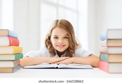 education and school concept - smiling little student girl with many books at school - Powered by Shutterstock
