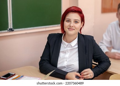 Education and school concept. A young girl at the desk watches and listens to the teacher. Generation Z - Shutterstock ID 2207360489