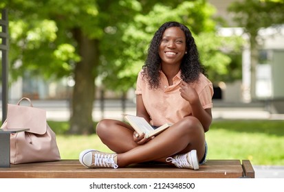 Education, School And People Concept - Happy Smiling African American Student Girl Reading Book In City