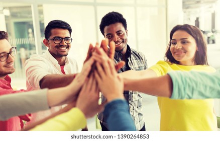 education, school, teamwork, gesture and people concept - group of international students making high five