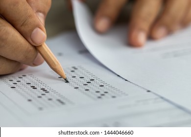 Education School Test Concept : Hands Student Holding Pencil For Testing Exams Writing Answer Sheet Or Exercise For Taking Fill In Admission Exam Multiple Carbon Paper Computer At University Classroom