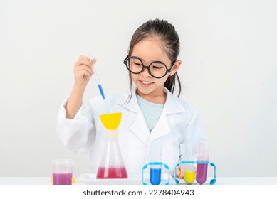 education, science and children concept girl in goggles with magnifier studying test tube with chemical at home laboratory - Powered by Shutterstock