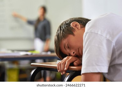 Education, student and boy sleeping on desk, tired and bored in classroom, burnout and fatigue in school. Youth, child and kid with dream on notebook, table and lazy for knowledge, rest and relax - Powered by Shutterstock