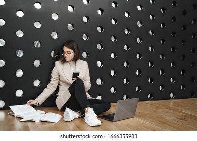 Education, Student Lifestyle And Career Concept. Portrait Of Young Smart Girl Working On Project, Sit Co-working Space Or College Lounge On Floor, Reading Book And Type Report In Laptop