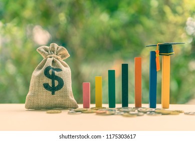 Education Or Student Loan, Financial Aid And Scholarship Concept : US Dollar Cash Bag, Coins, A Black Graduation Cap Or Hat / Mortarboard On Rising Wood Pole, Depict The Increasing Cost Of Tuition Fee