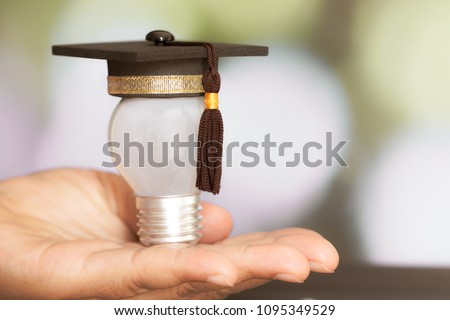Education study Creative concept: Mini Graduated hat with light bulb 
on Hands in blur background. Ideas with innovation creativity for Educational successs studies world, back to School