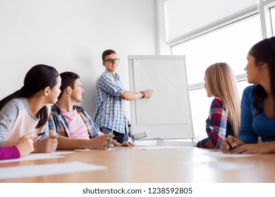 Education, Teamwork And People Concept - Group Of High School Students With Flip Chart