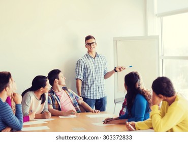 Konzept von Bildung, Teamwork und Menschen - Lächelnde Schüler mit weißer Tafel sitzen in einem Raum