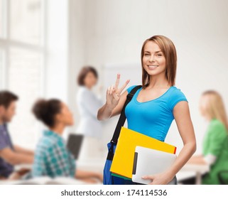 education, technology, gesture and people concept - smiling female student with bag, tablet pc computer and folders showing victory gesture