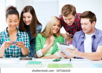 education, technology and internet - students looking at smartphones and tablet pc - Powered by Shutterstock