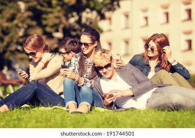 education, technology, internet, summer holidays, social networking and teenage concept - group of teenagers with smartphones - Powered by Shutterstock