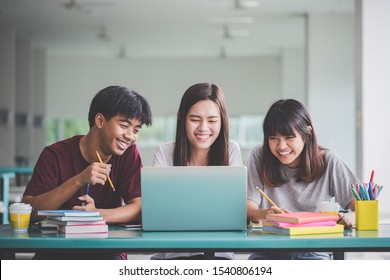 Education, University ,Technology and school concept. Group of friend or students smile happily with laptop on table on campus.