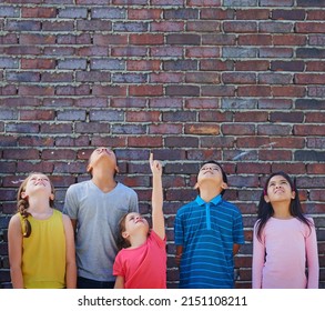 Education Will Take Us Higher. Shot Of A Diverse Group Of Children Looking Up Outside.