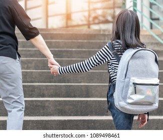 Educational Back To School, Parent's Day, Bring Kid To Work Concept With Elementary Student Girl Carrying Backpack Holding Woman Or Mother's Hand Walking Up Admission Office Building Going To Class