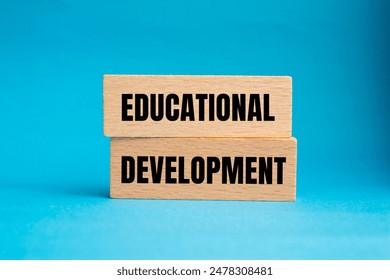 Educational development message written on wooden blocks with blue background. Conceptual educational development symbol. Copy space.