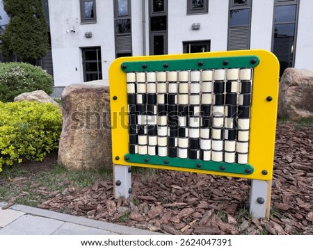 Educational play panel with rotating cubes in park setting. Designed to support cognitive development, coordination, and pattern recognition in young children through interactive learning