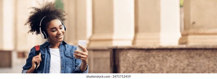 Educational Podcast. African American Student Girl Using Phone Wearing Wireless Headphones Walking At University Campus Outdoor. People And Gadgets, E-Learning Application Concept, Copy Space - Powered by Shutterstock