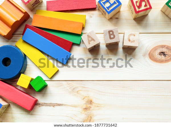Educational toys blocks, numbers, letters on the\
wooden table. Toys for kindergarten, preschool, or daycare. Copy\
space for text. Top\
view