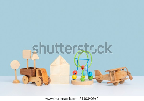Educational toys for preschool children. Wooden toy\
car truck, airplane, maze and constructor cubes on a blue\
background. Copy\
space