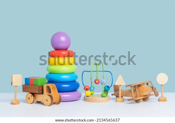 Educational toys for preschool\
children. Wooden and plastic toys on a blue background. Copy\
space