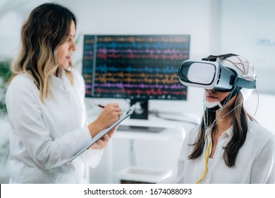 EEG Experiment In Neuroscience Research Laboratory. Female Patient Using VR Or Virtual Reality Goggles