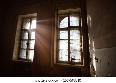 Eerie Light Of Candles In An Old Window With A Cobweb. Concept Of Horror And Halloween.