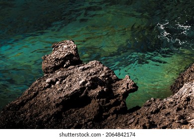 An Eerie Scenery Of A Cliff By The Azure Clear Ocean