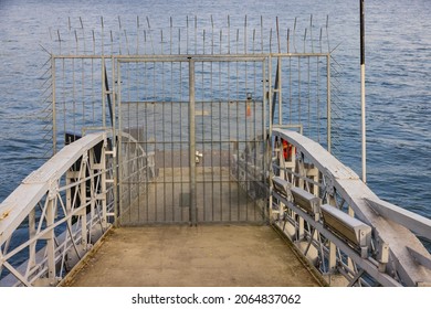 An Eerie Scenery Of A Closed Pier With A Metallic Gate In The Ocean