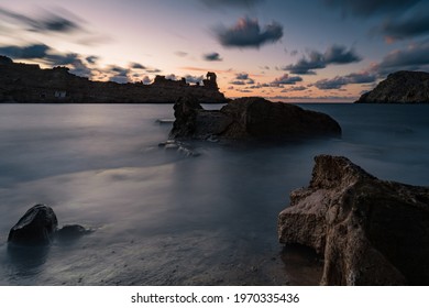 An Eerie Scenery Of The Clouds Above The Rocky Outcrops In The Ocean