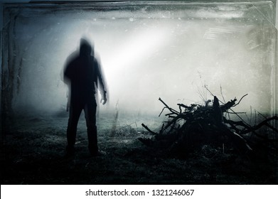 An eerie silhouette of a lone hooded figure in a field With a dark, spooky blurred abstract, grunge effect edit.  - Shutterstock ID 1321246067