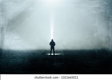 An eerie silhouette of a lone hooded figure in a field with a torch. With a dark, spooky blurred abstract, grunge effect edit.  - Shutterstock ID 1321665011