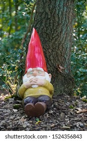 EEXT, NETHERLANDS - SEPTEMBER 22, 2019: A garden gnome with a red hat laying down in the woods in the fairytale forest in the Netherlands