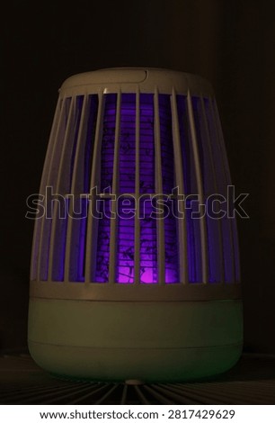 Effective bug zapper using purple UV light to attract and eliminate mosquitoes. Close-up of the electrified grid with trapped insects, providing a solution for pest-free environments.