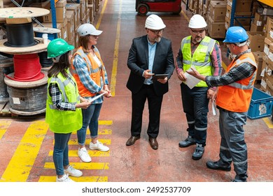 Effective Management in Action: Businessman Engaging and walking with Warehouse Worker and Engineer, Utilizing Digital Tablet - Powered by Shutterstock