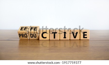 Effective and productive symbol. Turned wooden cubes, changed the word 'productive' to 'effective'. Beautiful wooden table, white background, copy space. Business, effective and productive concept.