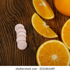 Effervescent Orange Tablets. Fizzy Fruit Tablets Pile, Disease Prevention Concept, Pink Orange Effervescent Vitamine Supplement On Wood Background