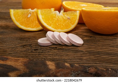 Effervescent Orange Tablets. Fizzy Fruit Tablets Pile, Disease Prevention Concept, Pink Orange Effervescent Vitamine Supplement On Wood Background