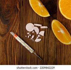 Effervescent Orange Tablets With Medical Thermometer. Fizzy Fruit Tablets Pile, Disease Prevention Concept, Pink Orange Effervescent Vitamine Supplement On Wood Background