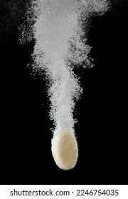 effervescent tablet dissolving in water against a black background