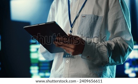Efficient employee walking through data center units providing processing resources for different workloads. Admin troubleshooting server rigs tasked with solving complex operations, close up