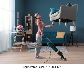 Efficient happy housewife cleaning up her apartment: she is lifting the armchair with one hand and vacuuming the floor, effortless easy housekeeping concept - Shutterstock ID 1815858422