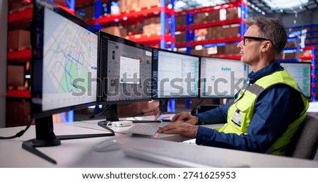 Efficient Logistics Manager Overseeing Warehouse Operations With Multiple Screens In Business Center.