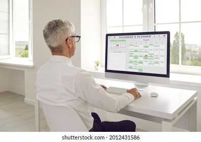 Efficient senior administrator at desk with pc computer checks smart virtual electronic memo Calendar Schedule Time Planner, prioritizes urgent staff day tasks, organizes busy week month project list