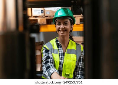 Efficient Warehouse Operations: Female Forklift Driver Poses and Drives Worklift at Distribution Warehouse - Powered by Shutterstock