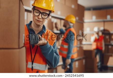 Efficient warehouse worker scanning a barcode on a delivery box label using a handheld scanner, logistics and shipping concept