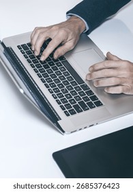 Efficient Work Flow: A High-Angle View of a Professional Typing on a Laptop with a Tablet