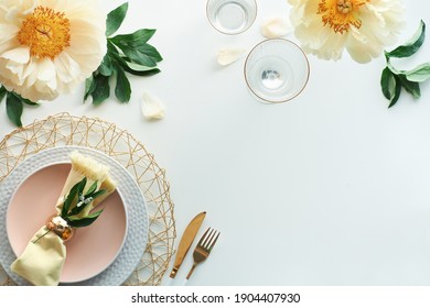 Effortless Golden Birthday Dinner Table Decor. Pale Yellow Peony Flowers And Late Spring, Summer Flat Lay. White Dinner Table, White And Gold Utensils, Decorated With Flowers, Text Place