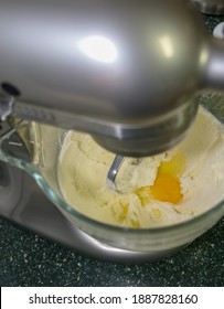 Egg Added To Butter And Sugar Mixture In A Mixer Glass Bowl For Making Sugar Cookies.